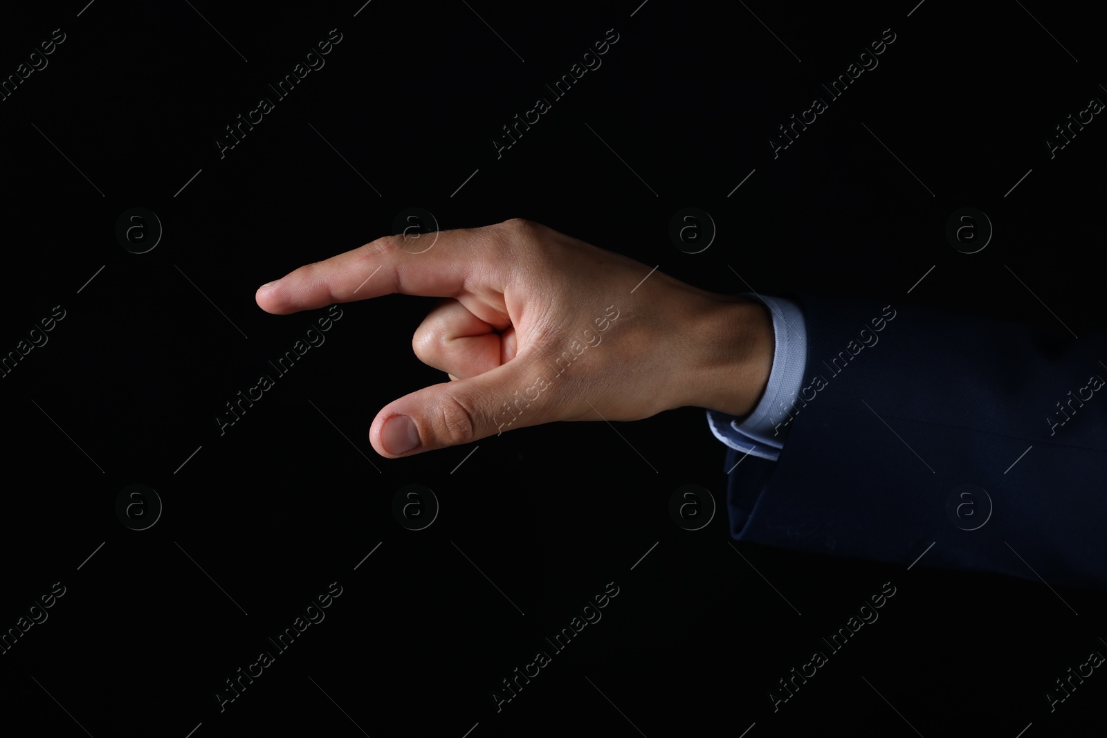 Photo of Man touching something on black background, closeup