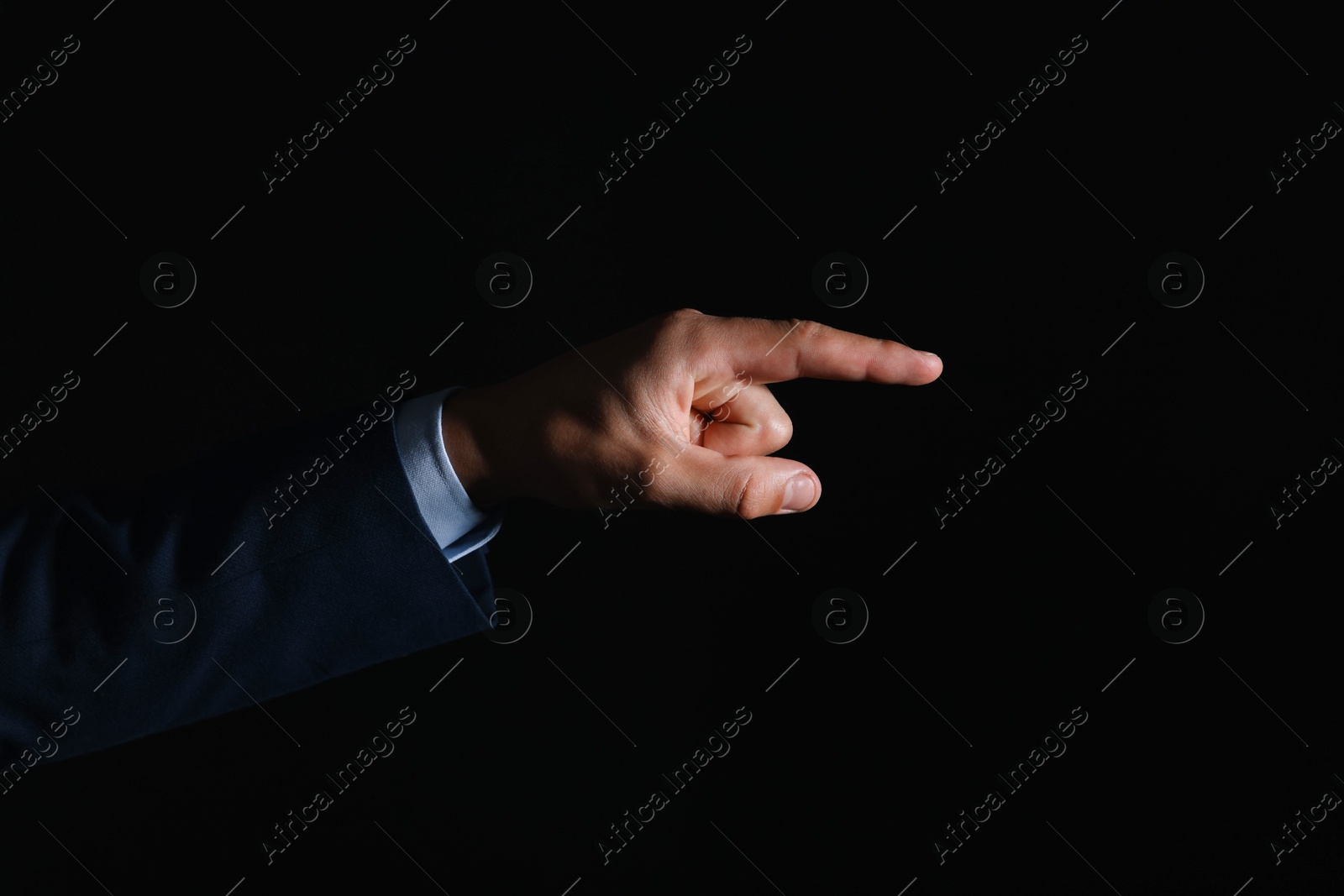Photo of Man touching something on black background, closeup