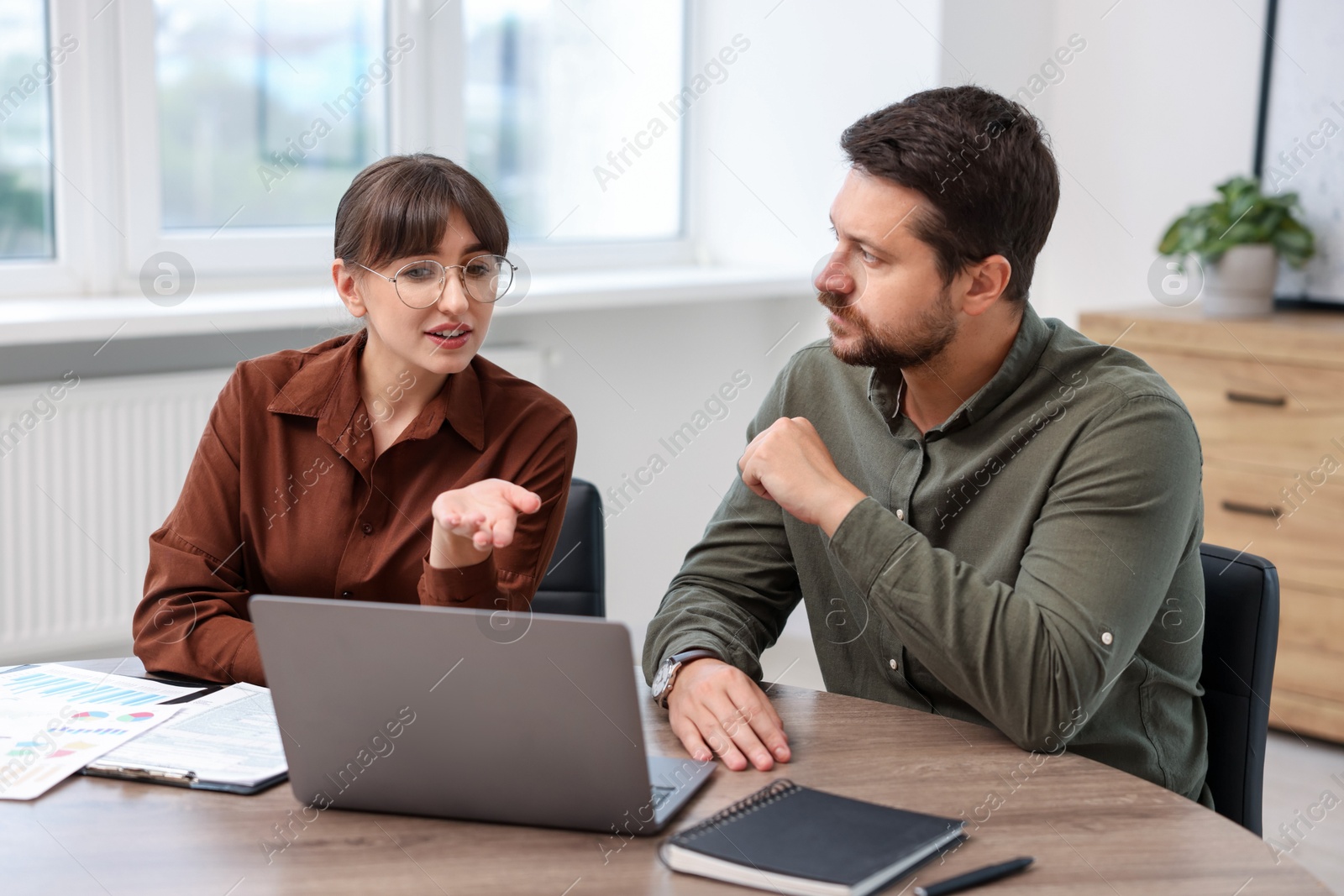 Photo of Consultant working with client at table in office. Business meeting