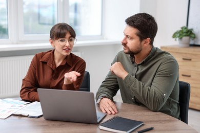 Photo of Consultant working with client at table in office. Business meeting