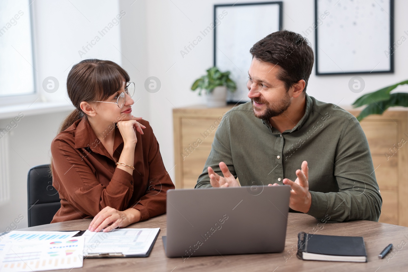 Photo of Consultant working with client at table in office. Business meeting