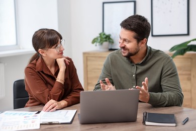 Photo of Consultant working with client at table in office. Business meeting