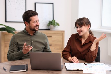 Photo of Consultant working with client at table in office. Business meeting
