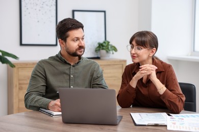 Photo of Consultant working with client at table in office. Business meeting