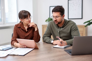 Photo of Consultant working with client at table in office. Business meeting
