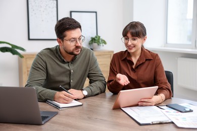 Photo of Consultant working with client at table in office. Business meeting