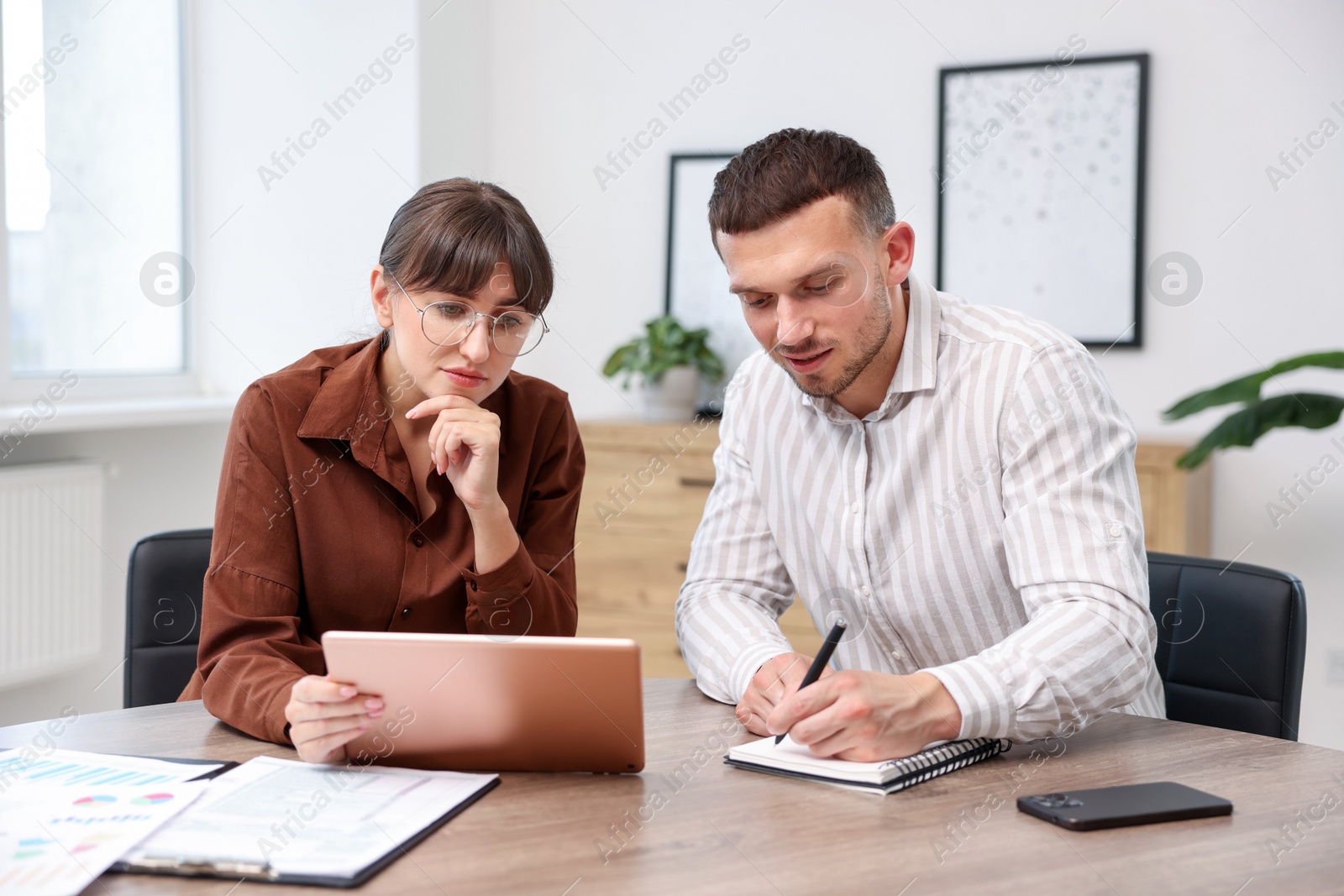 Consultant working with client at table in office. Business meeting Photo of Consultant working with client at table in office. Business meeting
