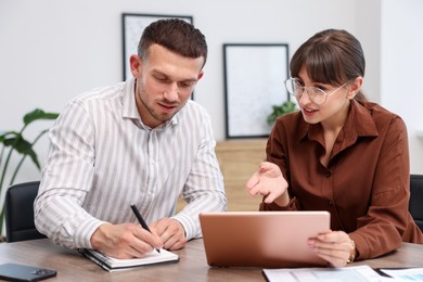 Photo of Consultant working with client at table in office. Business meeting
