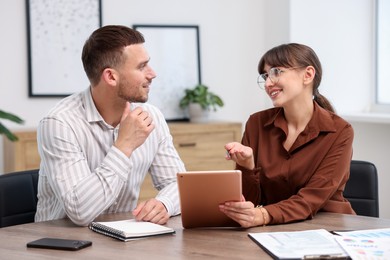 Photo of Consultant working with client at table in office. Business meeting