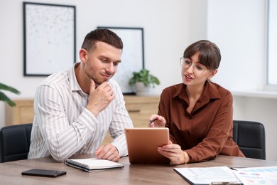 Photo of Consultant working with client at table in office. Business meeting