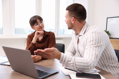 Photo of Consultant working with client at table in office. Business meeting