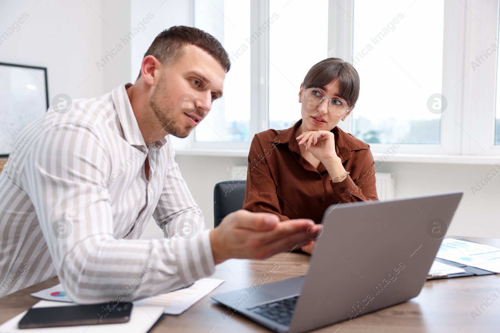 Consultant working with client at table in office. Business meeting Photo of Consultant working with client at table in office. Business meeting