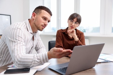 Photo of Consultant working with client at table in office. Business meeting