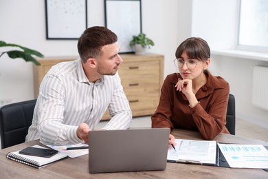 Photo of Consultant working with client at table in office. Business meeting