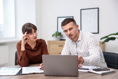 Photo of Consultant working with client at table in office. Business meeting