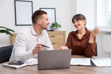 Photo of Consultant working with client at table in office. Business meeting