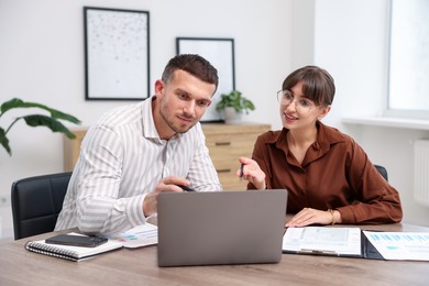Photo of Consultant working with client at table in office. Business meeting