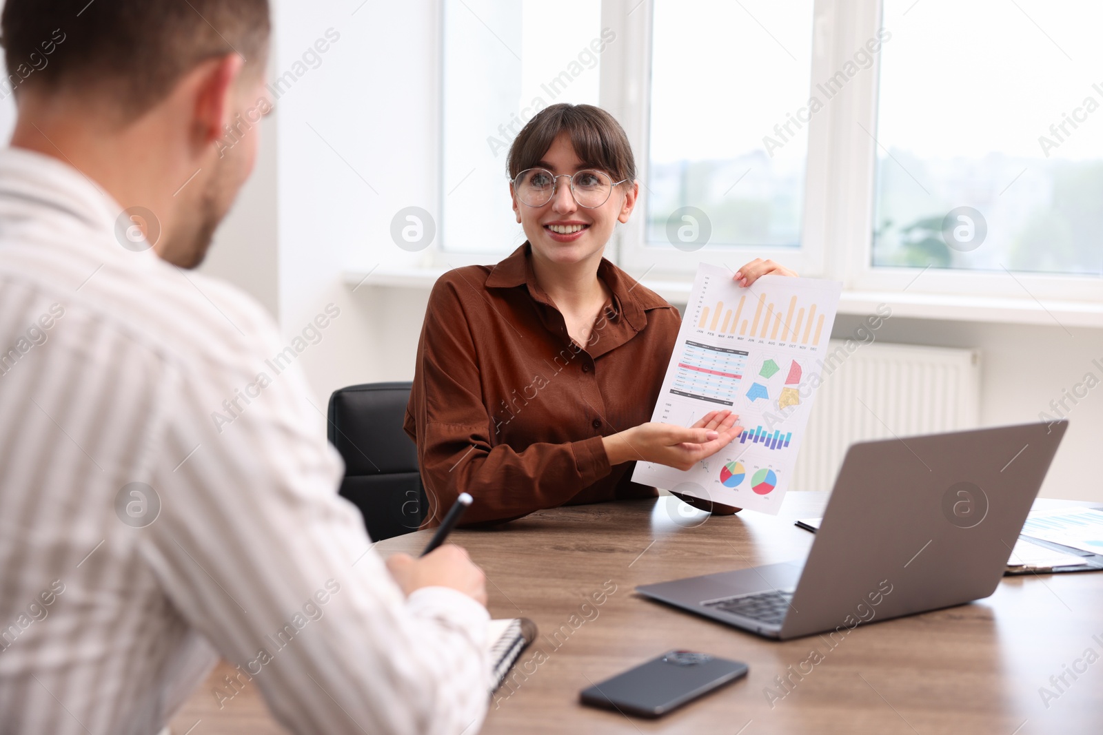 Consultant working with client at table in office. Business meeting Photo of Consultant working with client at table in office. Business meeting