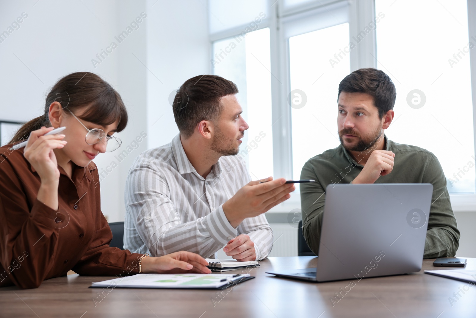 Photo of Couple having meeting with business consultant at table in office