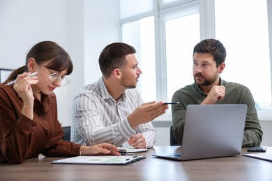 Photo of Couple having meeting with business consultant at table in office