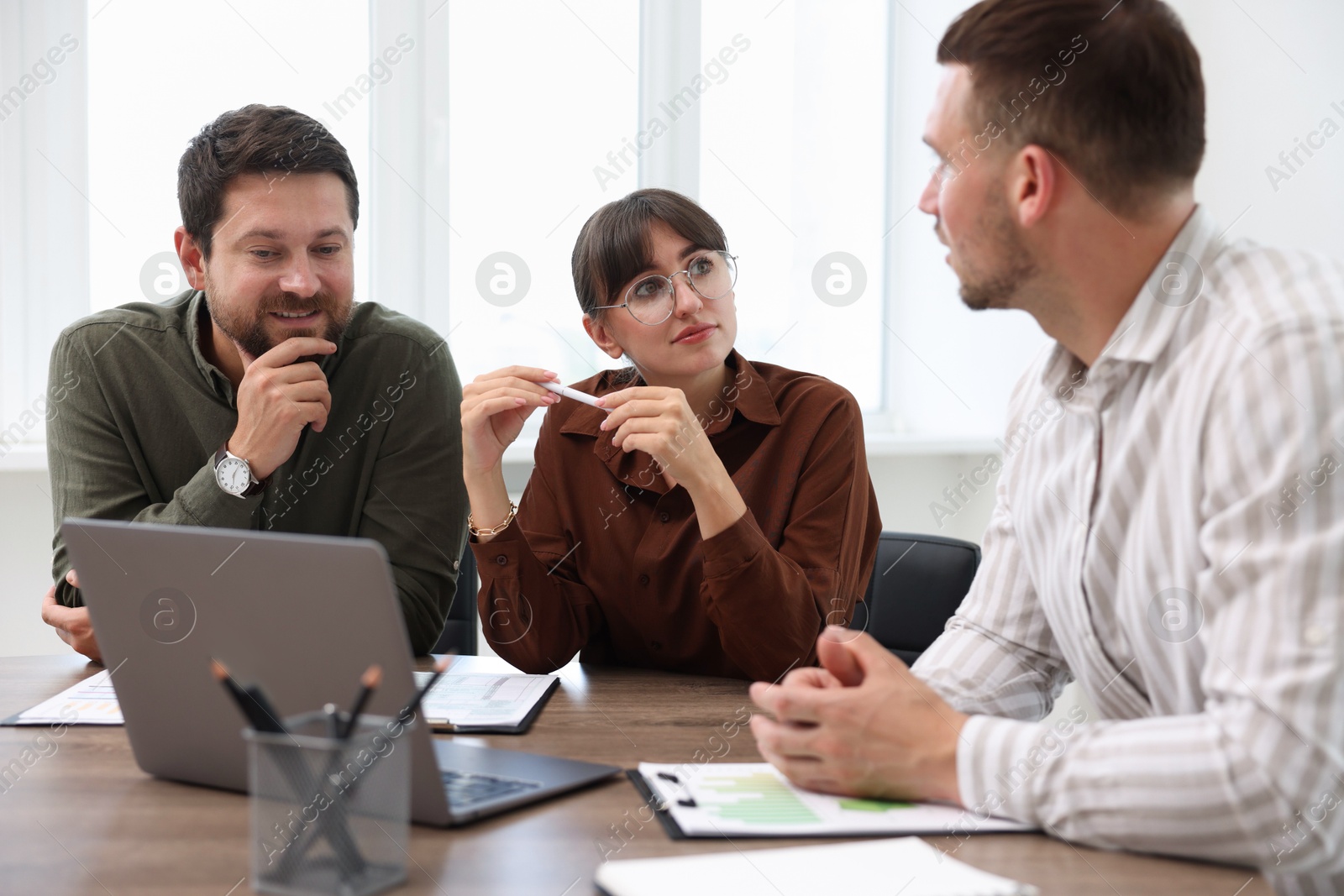 Photo of Couple having meeting with business consultant at table in office