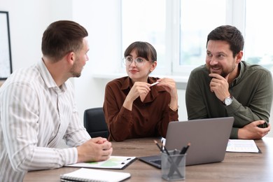Photo of Couple having meeting with business consultant at table in office