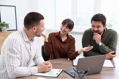 Photo of Couple having meeting with business consultant at table in office