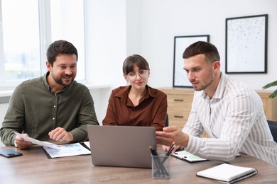 Photo of Couple having meeting with business consultant at table in office
