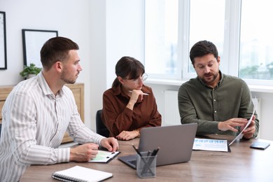 Photo of Couple having meeting with business consultant at table in office