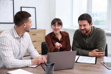 Photo of Couple having meeting with business consultant at table in office