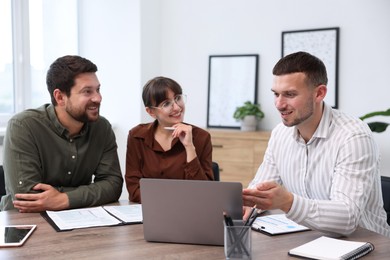 Photo of Couple having meeting with business consultant at table in office
