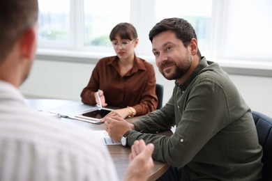 Photo of Couple having meeting with business consultant at table in office, selective focus