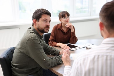 Photo of Couple having meeting with business consultant at table in office, selective focus