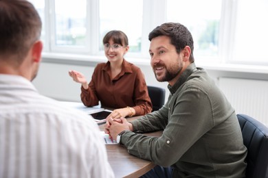 Photo of Couple having meeting with business consultant at table in office, selective focus