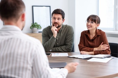 Photo of Couple having meeting with business consultant at table in office