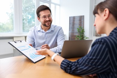 Photo of Consultant working with client at table in office. Business meeting