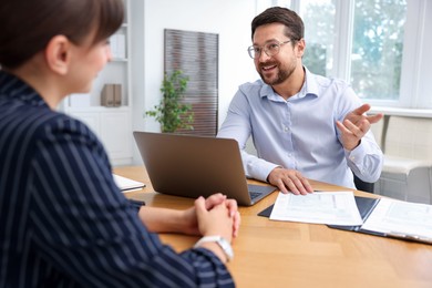 Photo of Consultant working with client at table in office. Business meeting