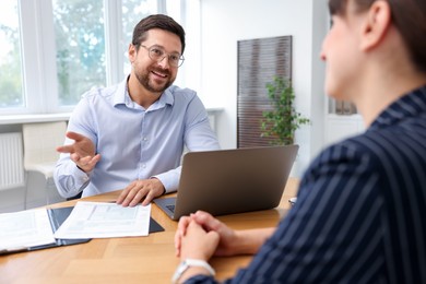 Photo of Consultant working with client at table in office. Business meeting