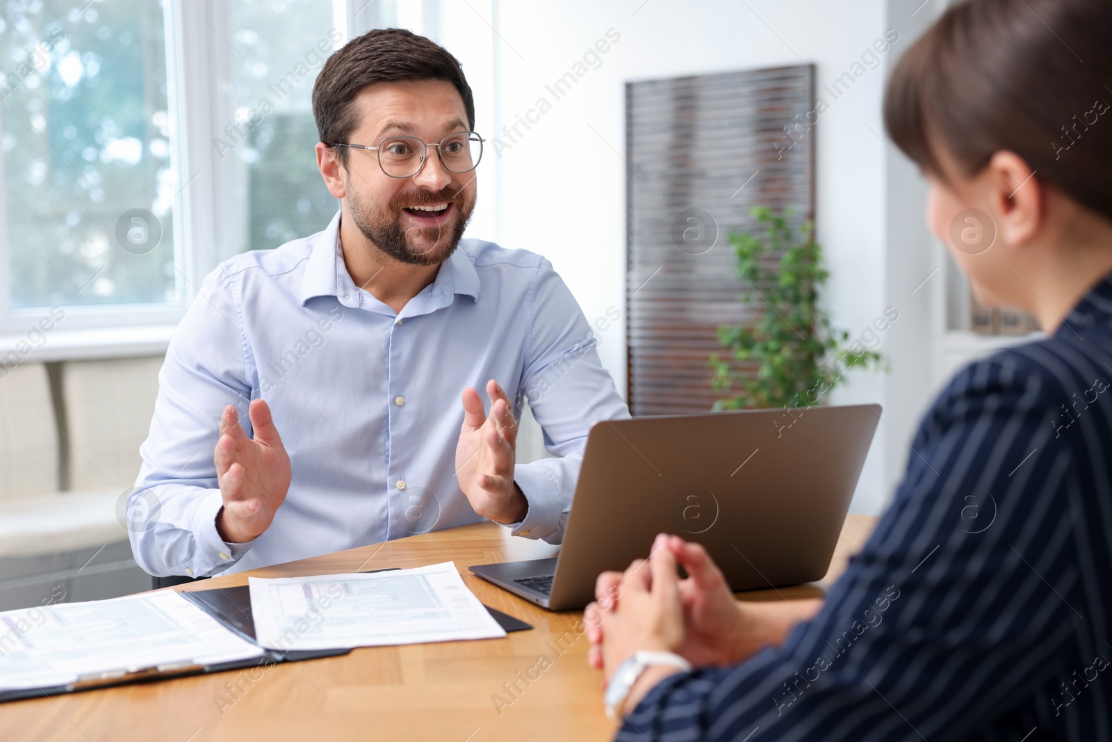 Consultant working with client at table in office. Business meeting Photo of Consultant working with client at table in office. Business meeting