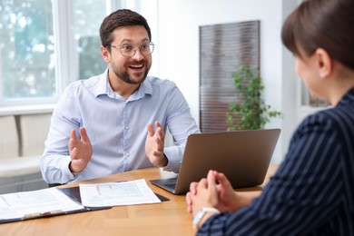Photo of Consultant working with client at table in office. Business meeting