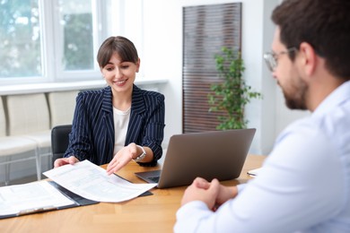 Photo of Consultant working with client at table in office. Business meeting