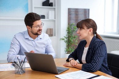 Photo of Consultant working with client at table in office. Business meeting