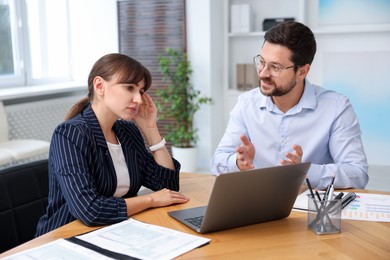 Photo of Consultant working with client at table in office. Business meeting