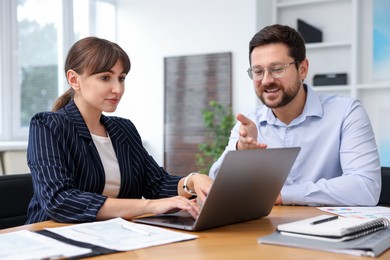 Photo of Consultant working with client at table in office. Business meeting