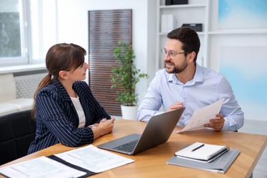 Photo of Consultant working with client at table in office. Business meeting