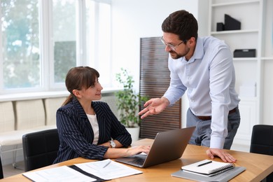 Photo of Consultant working with client at table in office. Business meeting