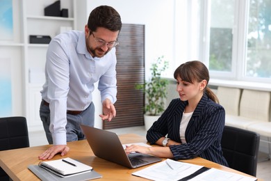 Photo of Consultant working with client at table in office. Business meeting