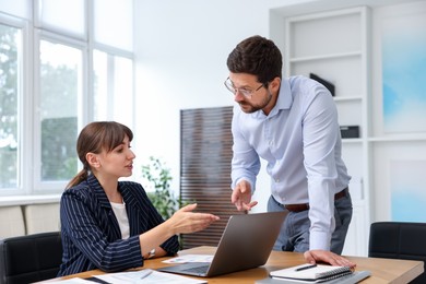 Photo of Consultant working with client at table in office. Business meeting