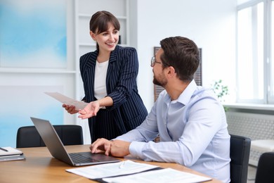 Photo of Consultant working with client at table in office. Business meeting
