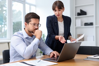 Photo of Consultant working with client at table in office. Business meeting